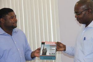 (L-R) Junior Minister in the Ministry of Communication and Works Hon. Troy Liburd handing over 12 BAOFENG short range two-way radios to Permanent Secretary in the Ministry of Communications and Works Ernie Stapleton at a handing over ceremony at the Nevis Island Administration’s conference room, Charlestown on June 25, 2015